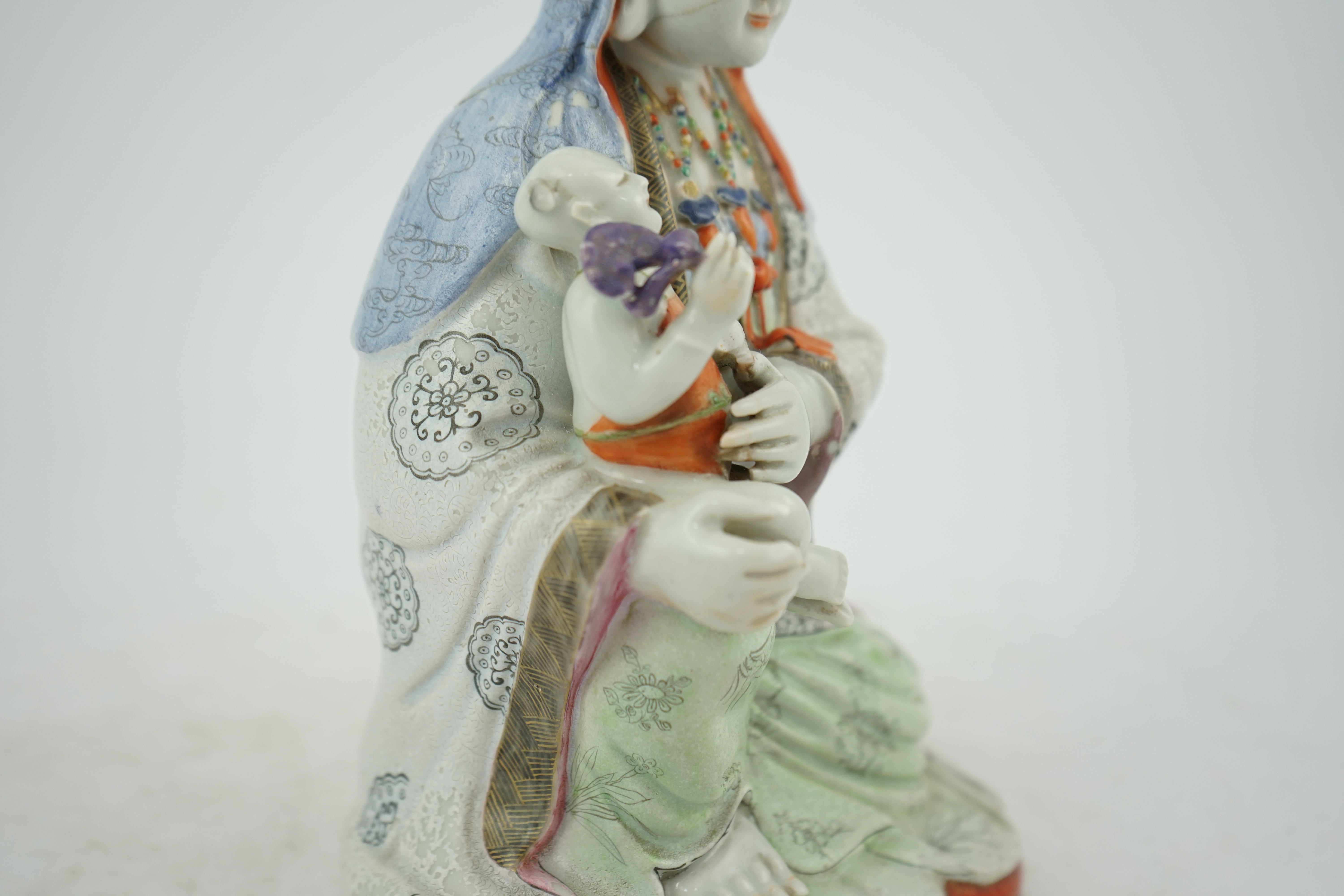 A Chinese enamelled porcelain group of Guanyin holding a child, Qianlong period